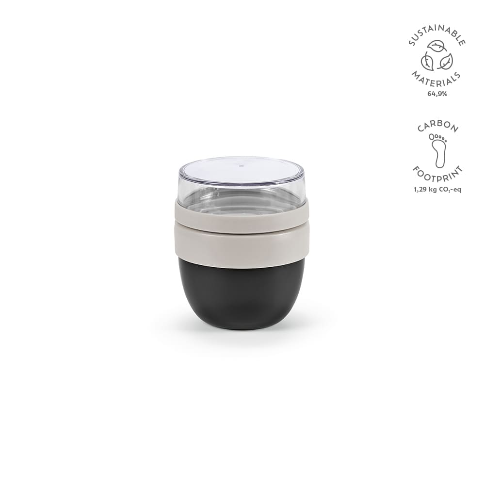 A food flask with two compartments, featuring a clear lid, grey and black body, and a logo. Sustainable materials used.