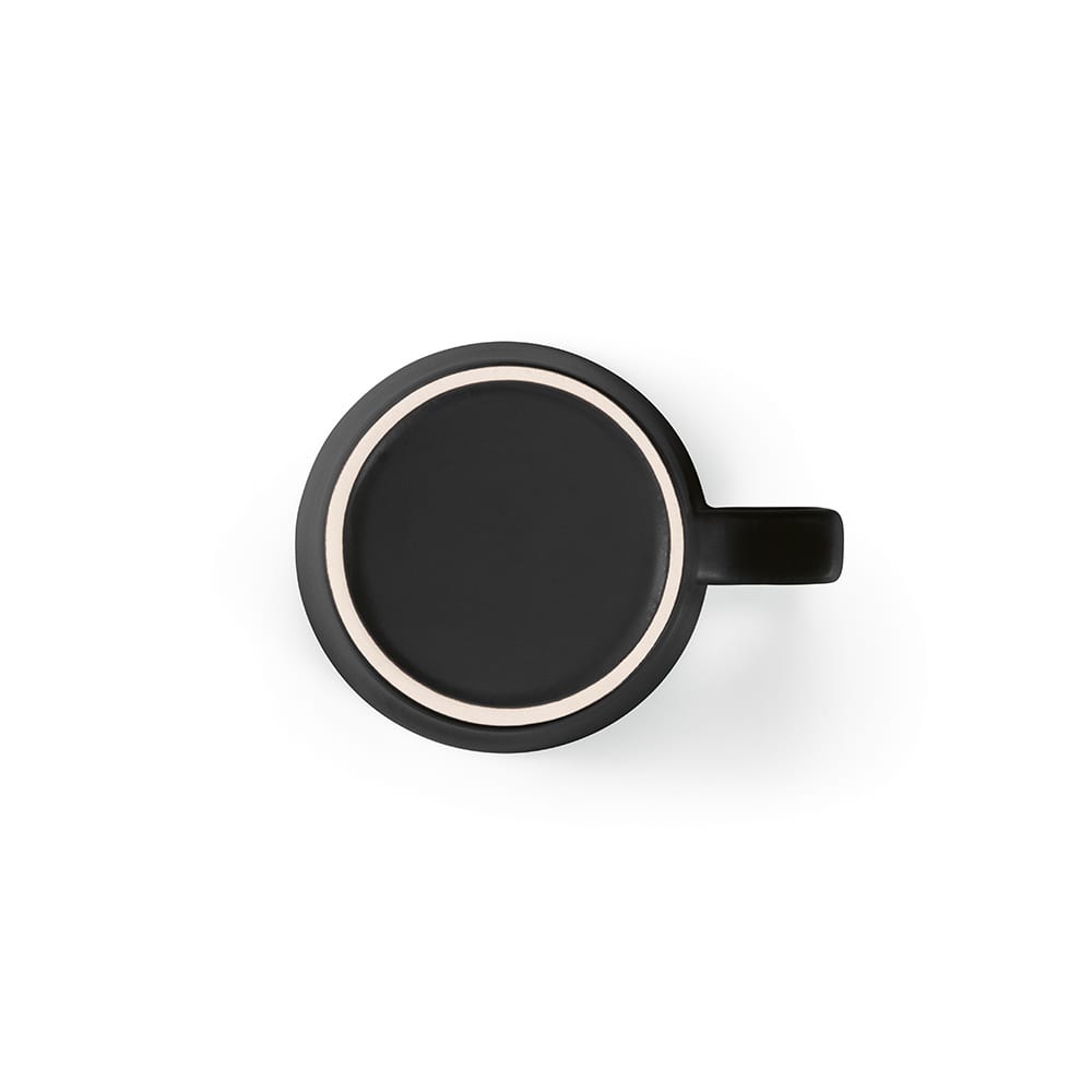 A ceramic mug with a matte black finish, featuring a contrasting light-coloured rim and a sturdy handle.