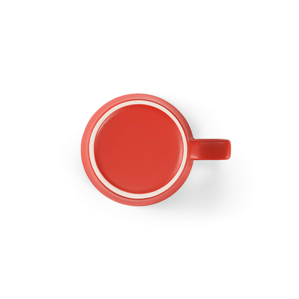 A red ceramic mug with a matt finish and a handle, featuring a white inner rim.