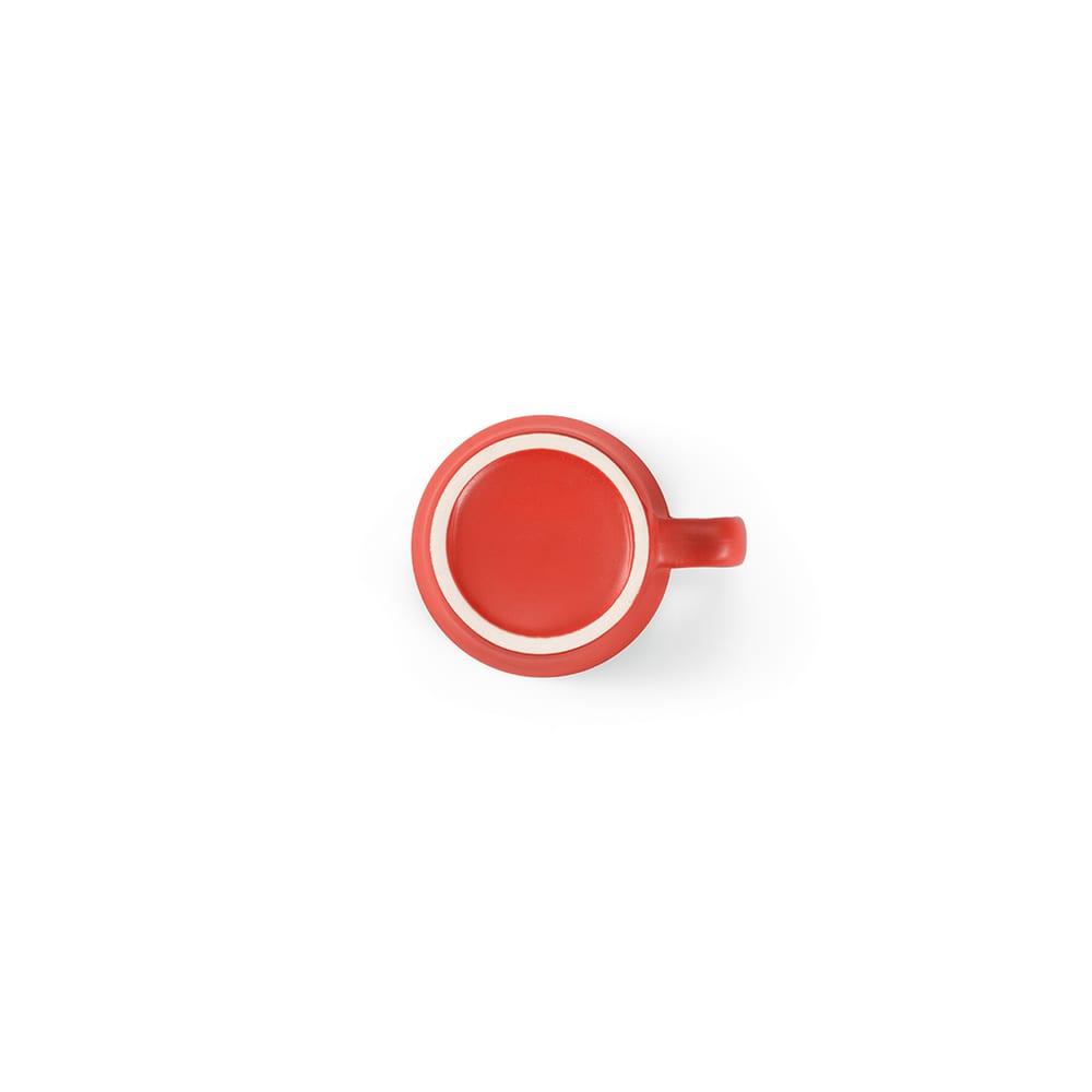 A ceramic mug in matte red finish with a circular white rim and a handle. The base is flat and smooth.