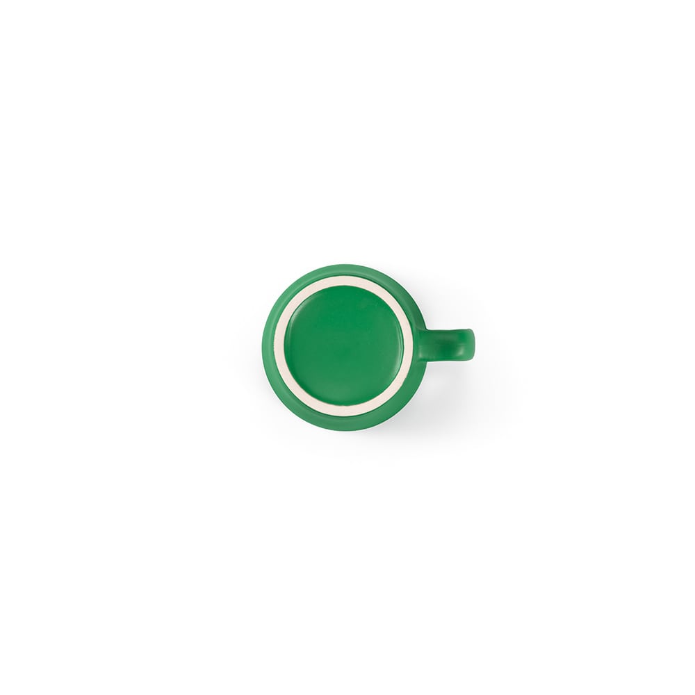 A ceramic mug with a matt finish, featuring a vibrant green colour and a contrasting rim. It has a handle and branding.