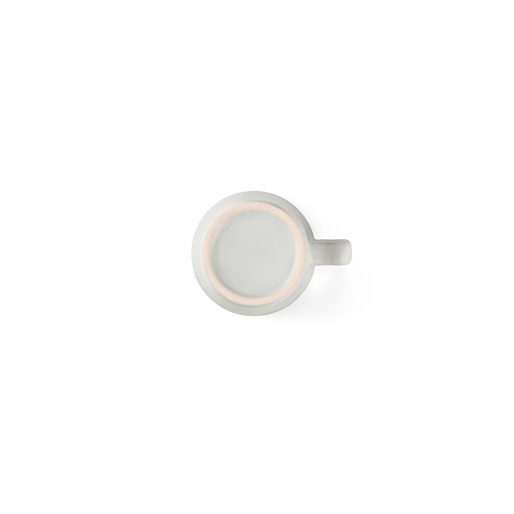 A ceramic mug with a matte finish, featuring a handle and a smooth surface, in a light colour.