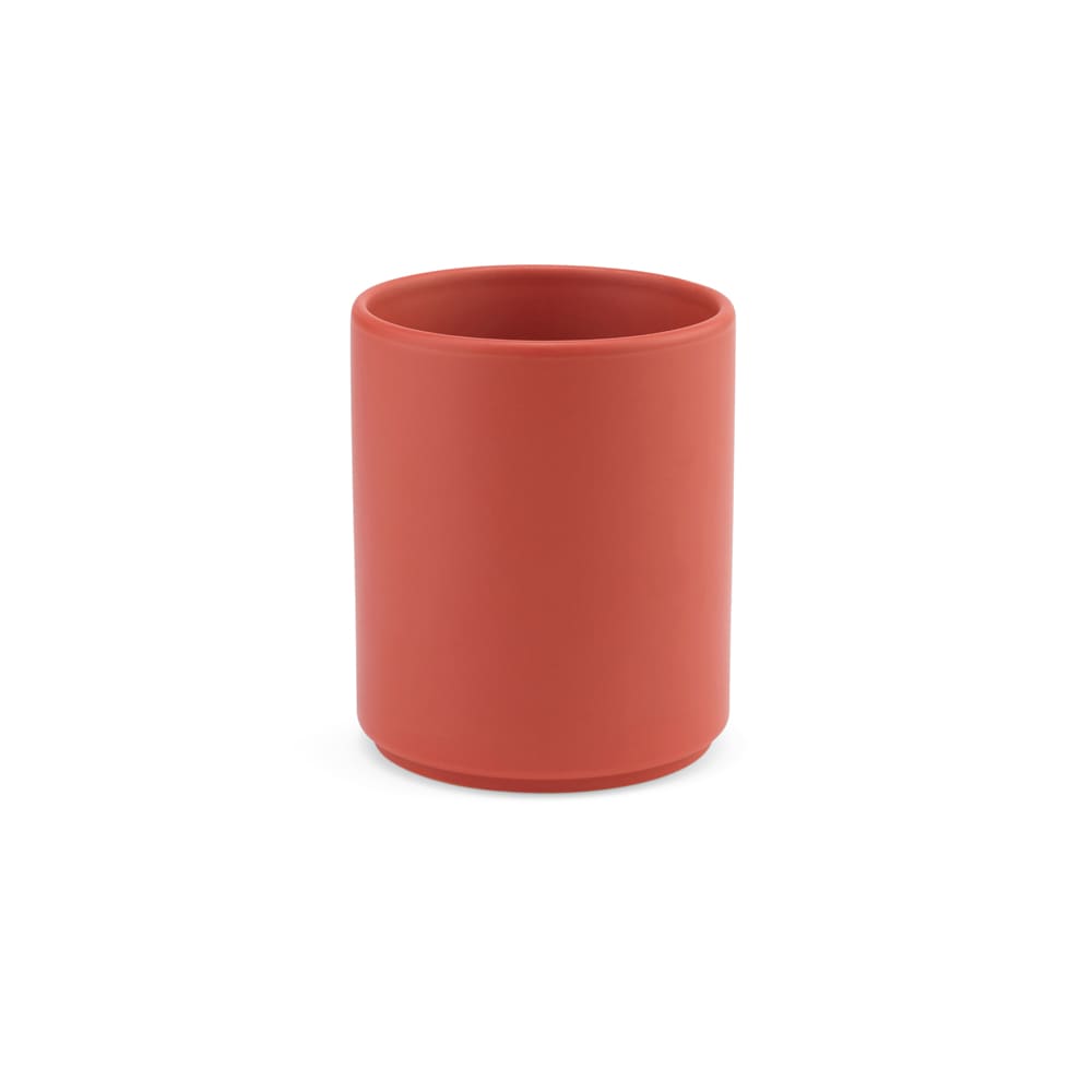 A ceramic mug in a matte coral finish, with a simple cylindrical design and no visible branding.