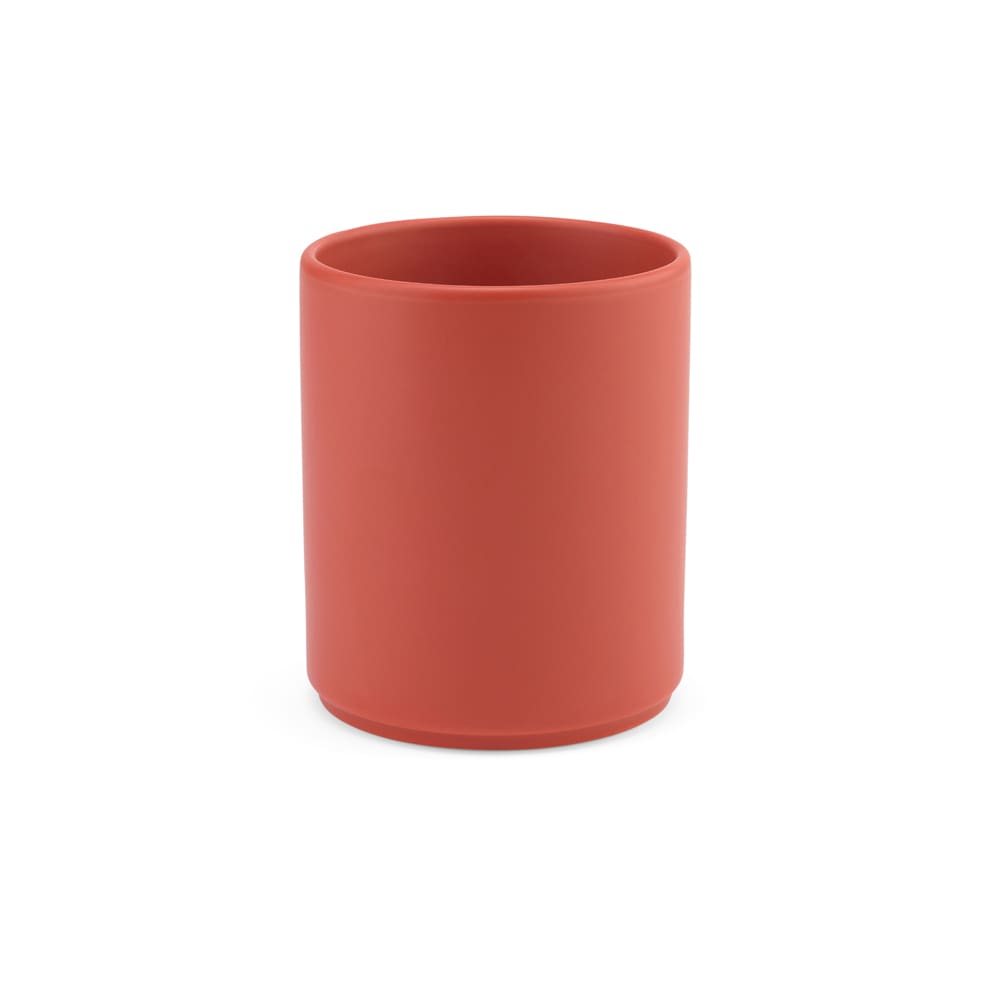A ceramic mug with a matt finish in a coral colour, featuring a sleek cylindrical design and a logo.