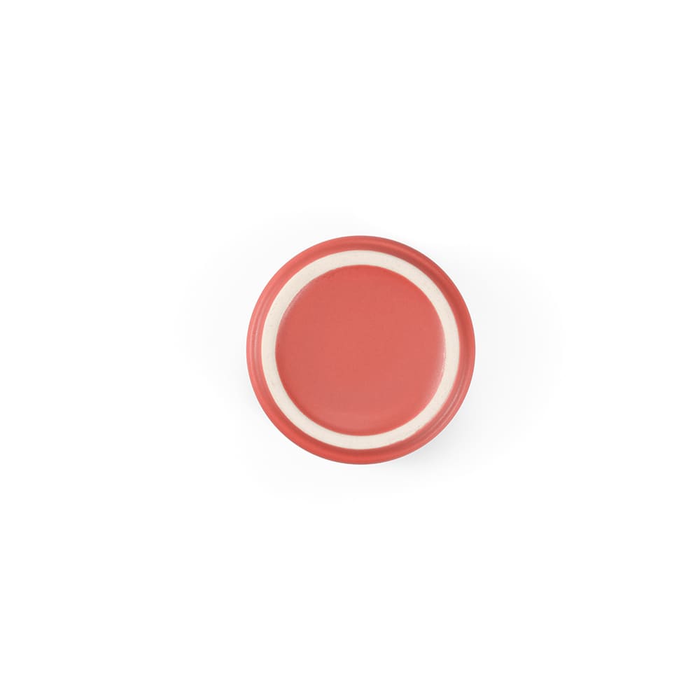 A ceramic plate with a matt coral finish and a white inner rim, featuring a smooth surface and rounded edges.