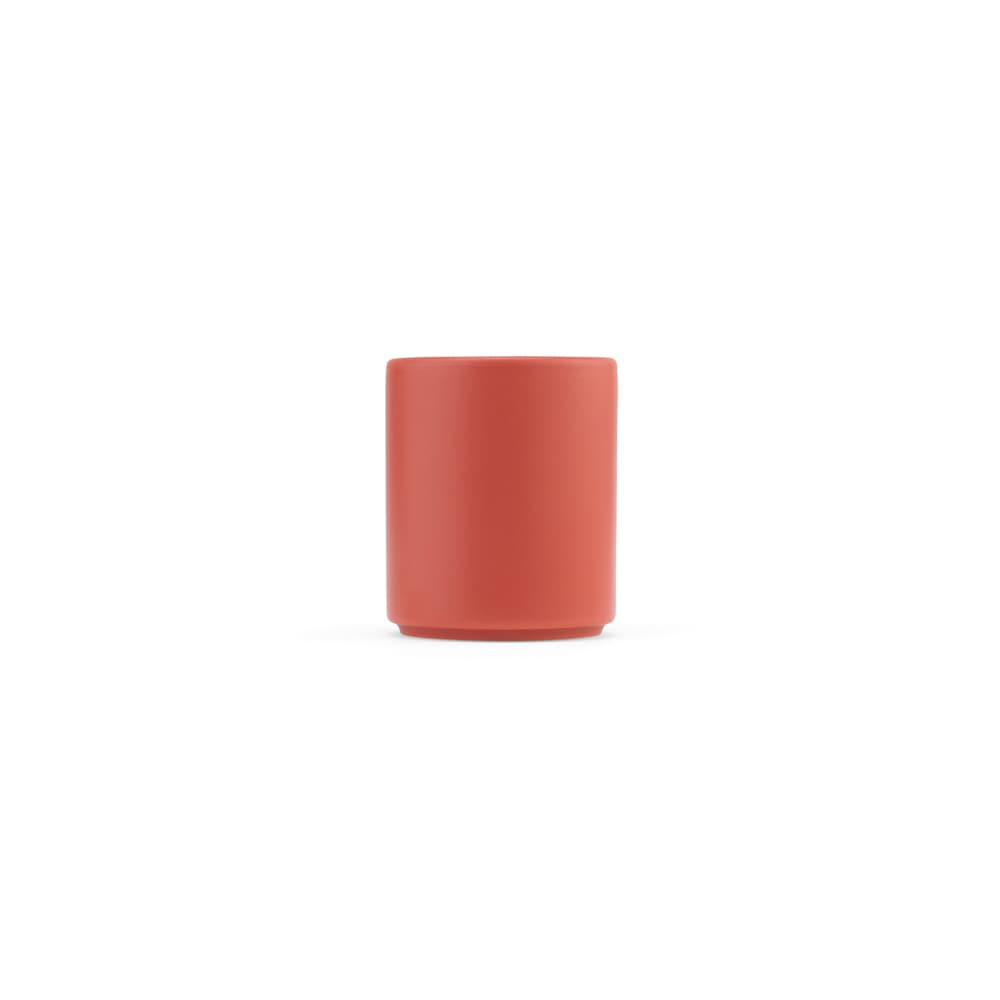 A ceramic mug in a matte finish, featuring a coral colour and a simple design. It has a logo.