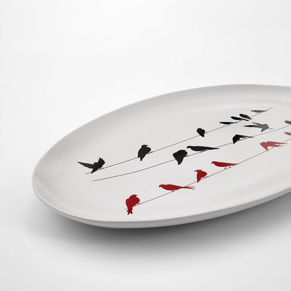 A ceramic platter with a matt finish, featuring black and red birds on a white background. Made in Portugal.