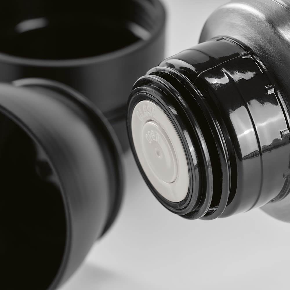 A drink bottle in black featuring a screw-on lid and two separate cups, accompanied by a carabiner.