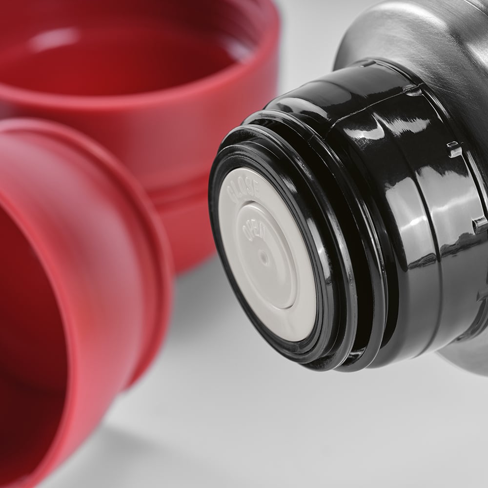 A drink bottle in metallic silver with black screw cap, accompanied by two red cups. It includes a carabiner.