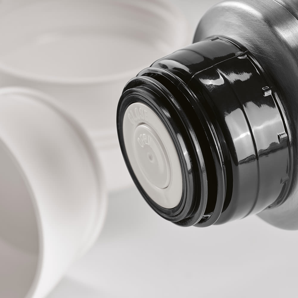 A drink bottle lid in black with white inner cap, accompanied by two white cups. The product includes a carabiner.