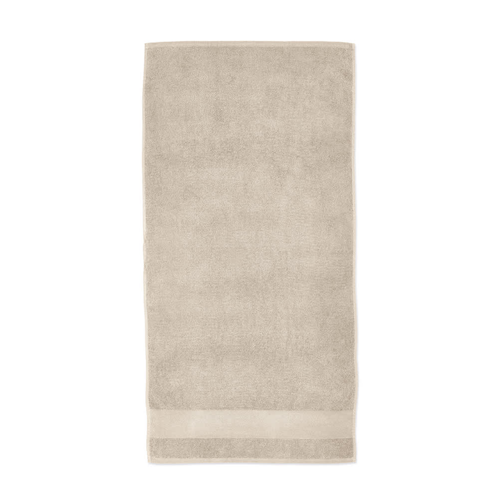 A beige cotton towel with a textured finish, featuring a border at the bottom and a logo.