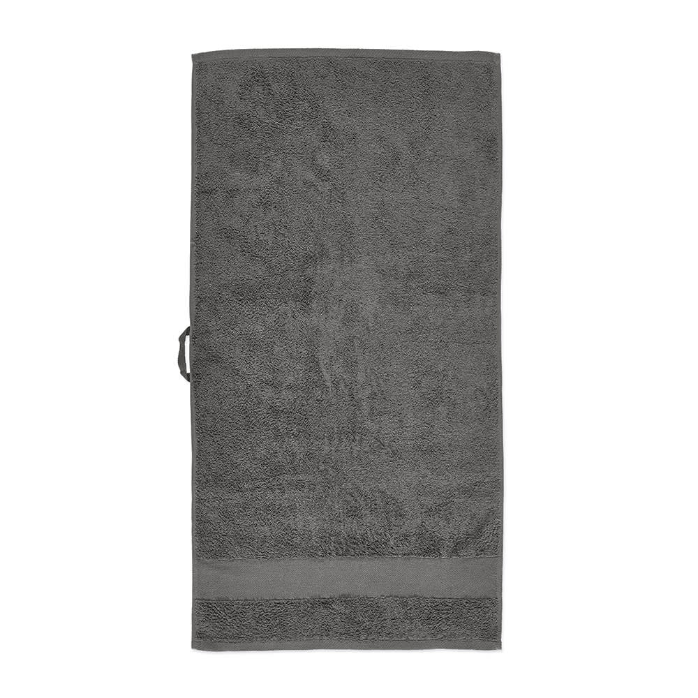 A grey towel made of cotton, featuring a textured surface and a subtle branding logo.