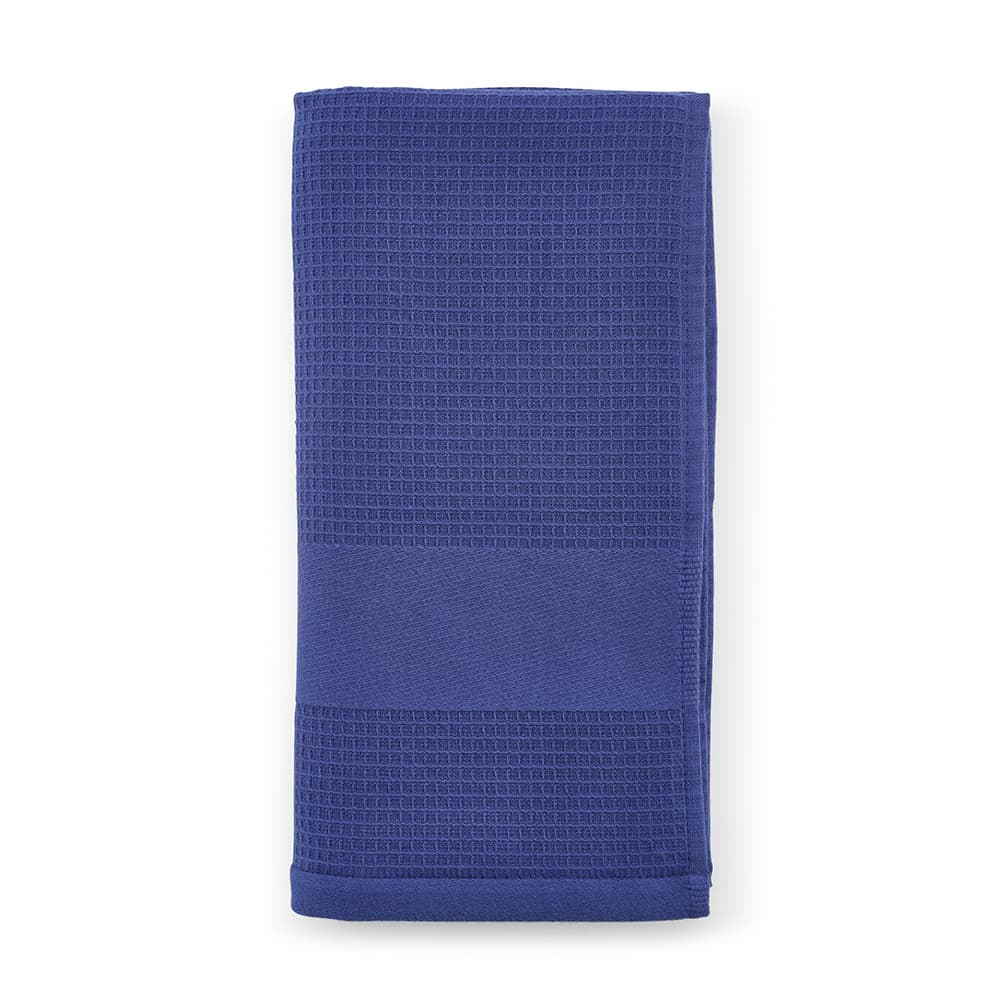 A folded cotton towel in a deep blue shade, featuring a textured pattern. It has a branding logo.
