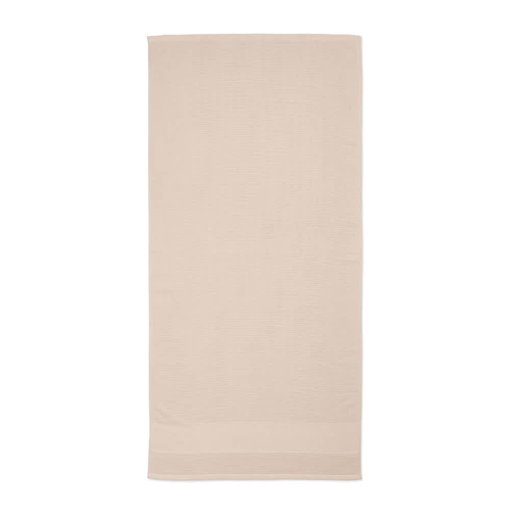 A beige cotton towel, named "Botticelli L Towel," featuring a subtle texture and branding. Made in Portugal.