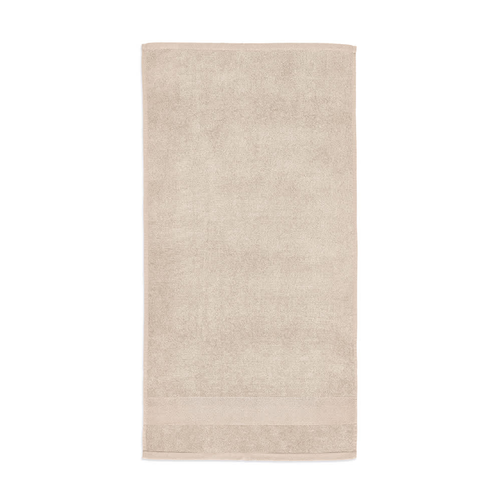 A soft, beige towel made from cotton, featuring a logo and a plush 500 gsm thickness. Made in Portugal.