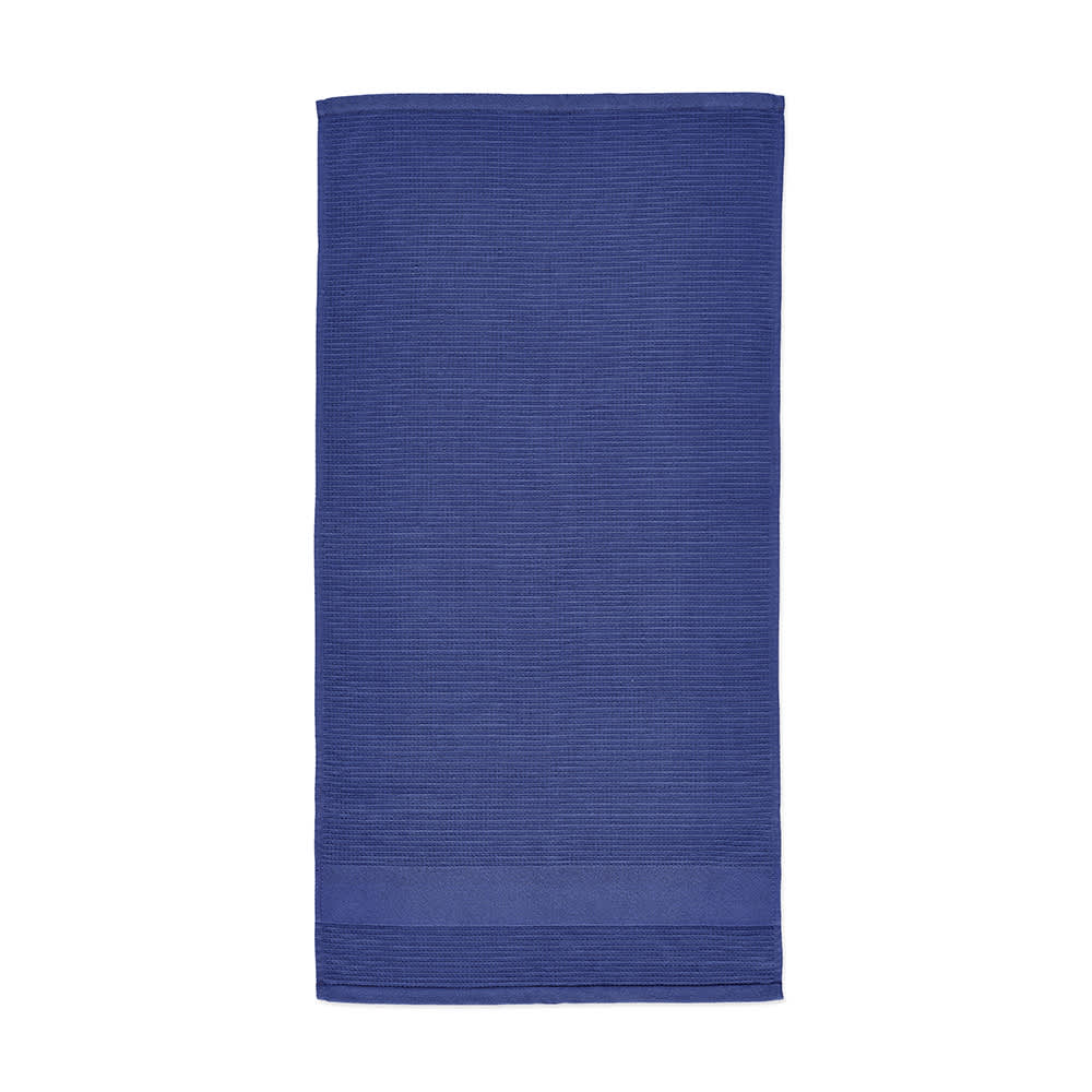 A navy blue towel with a textured design, featuring a simple hem and branding.