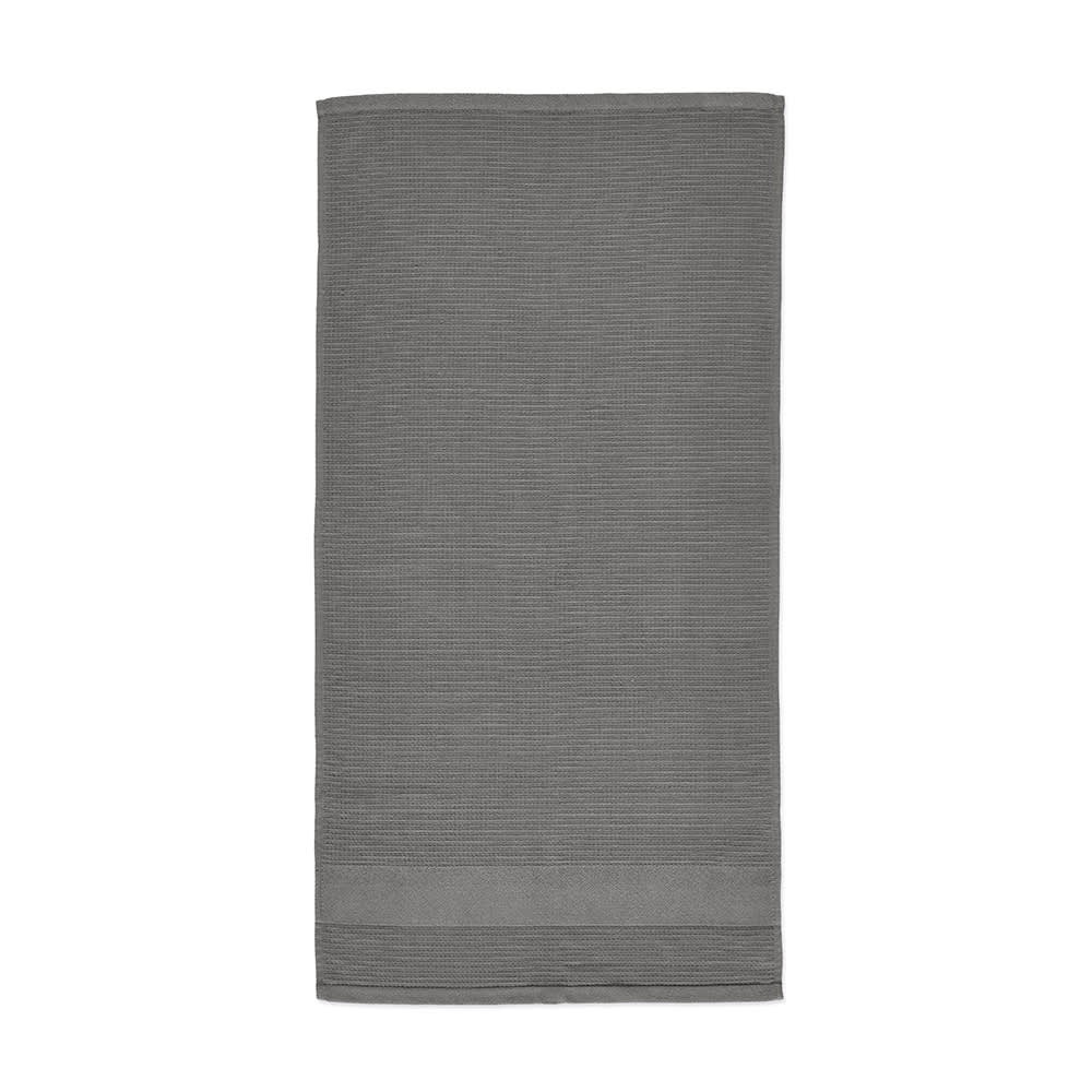 A grey cotton towel featuring a textured stripe design and a solid band at the bottom, with a branding logo.
