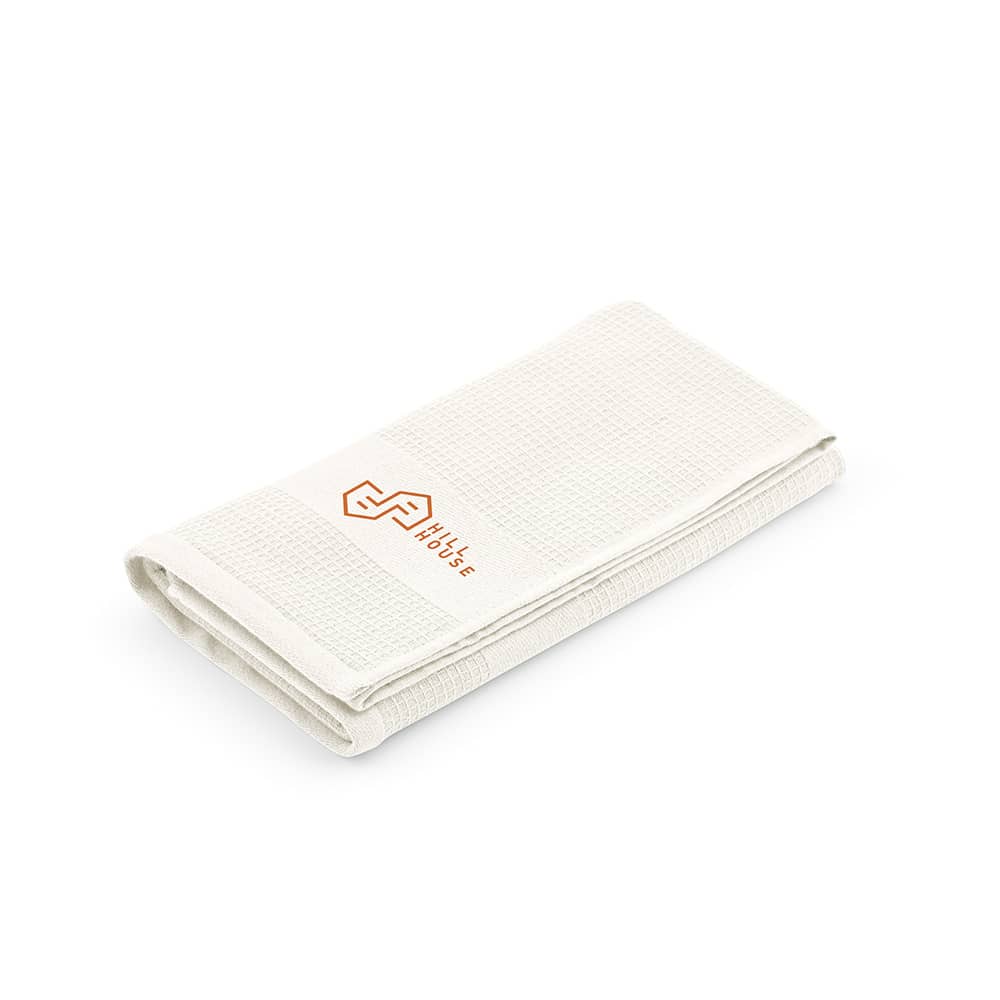 A folded white cotton towel with a textured surface and a branding label.