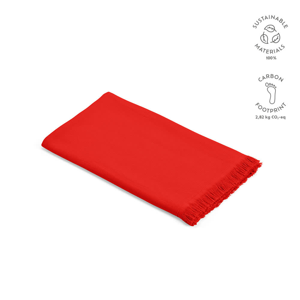 A red cotton towel with fringe edges, featuring sustainable materials and a logo. Made in Portugal.