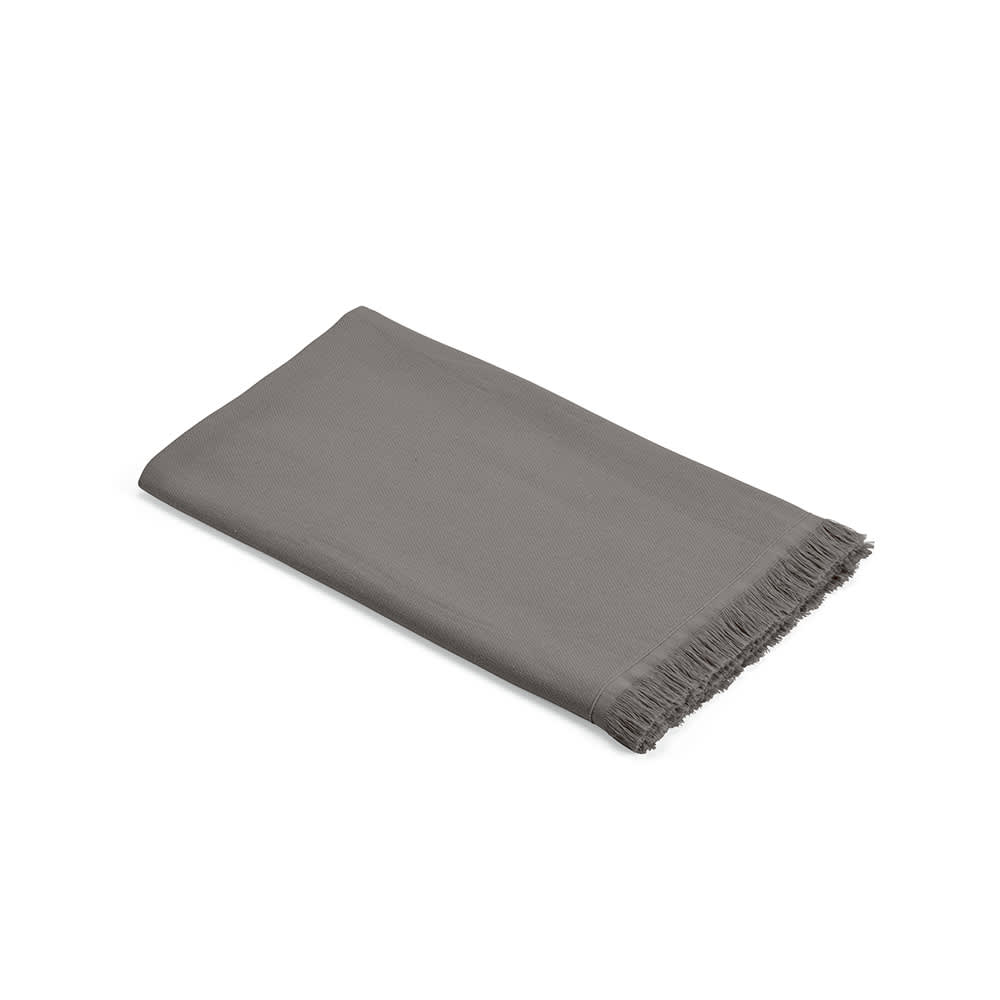 A grey cotton towel with fringed edges, featuring a smooth texture. It is made in Portugal.