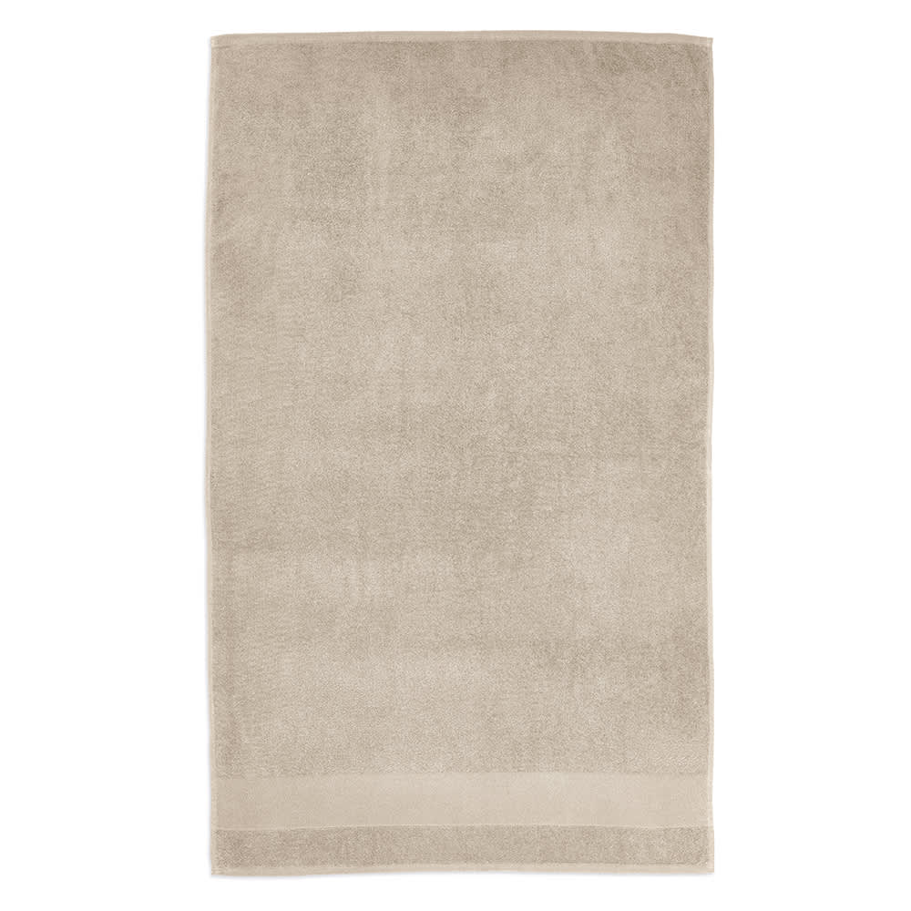 A beige towel made from cotton with a soft texture, featuring a subtle border and a branding logo.