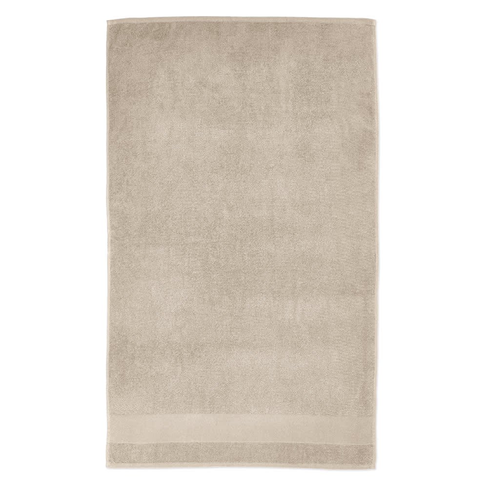 A beige towel made of cotton, featuring a simple design and a logo at the bottom. Thick and absorbent at 370gsm.