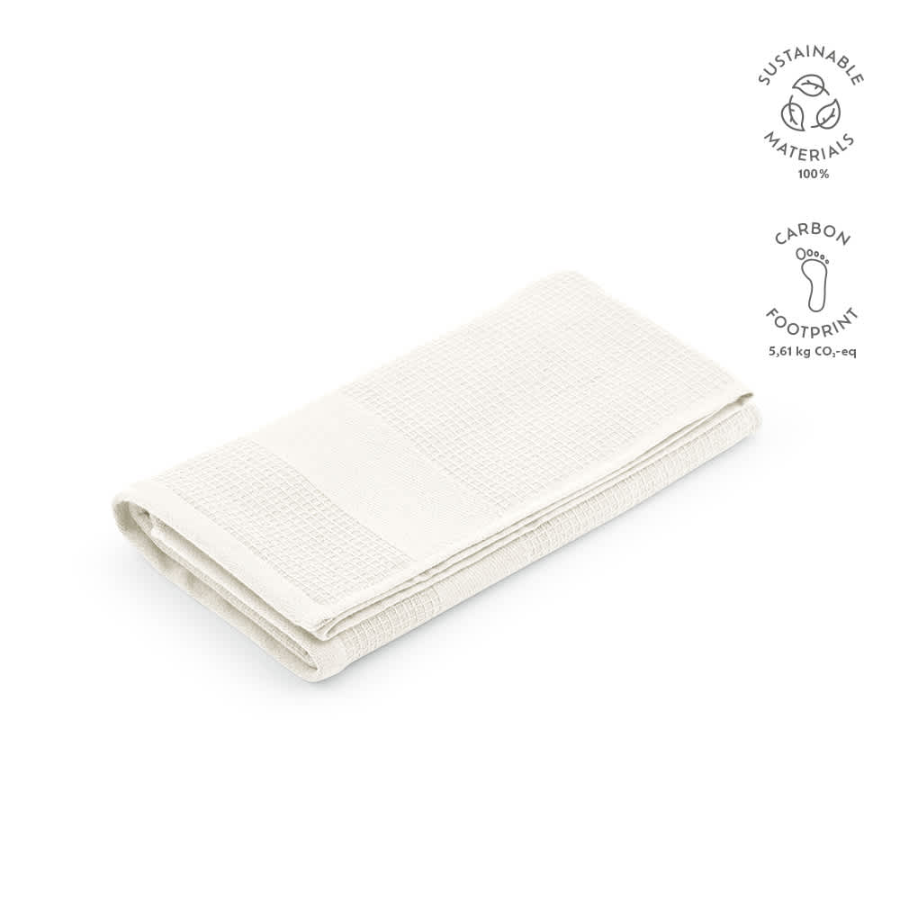 A folded towel in a light cream colour, made from recycled cotton, featuring a logo.