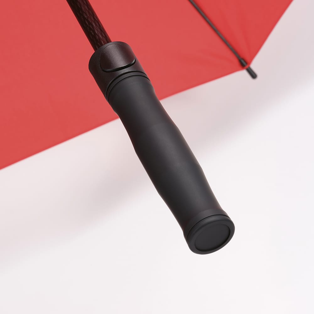 A red umbrella with a black handle, featuring a storm-proof design and automatic opening mechanism.