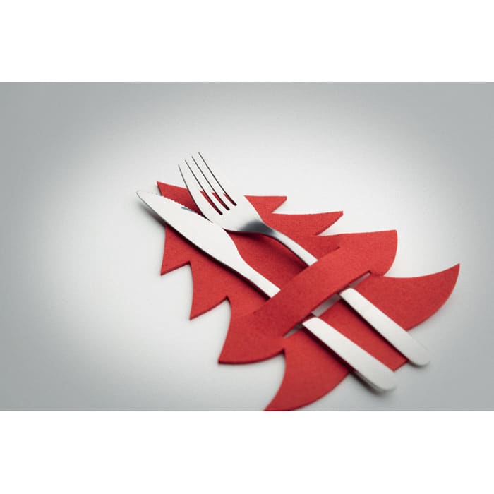A set of cutlery, including a fork and knife, resting on a red paper Christmas tree shape.