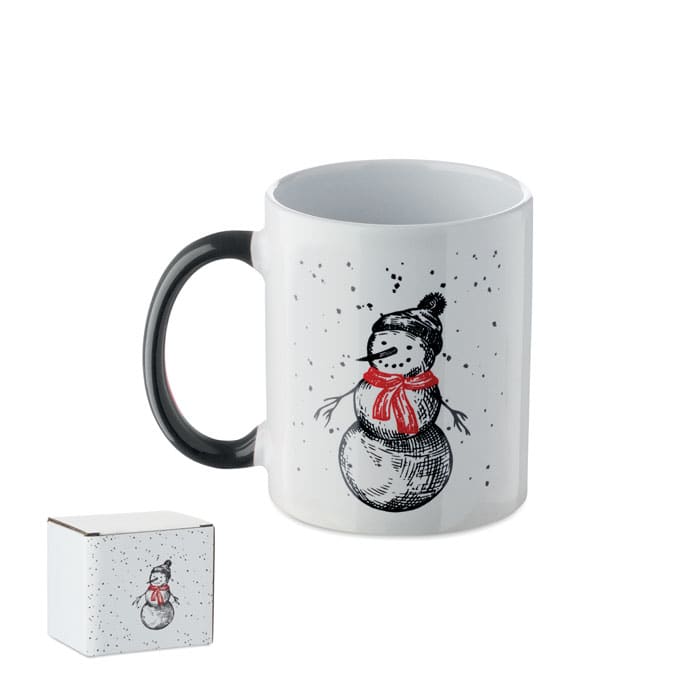 A white mug with a snowman design in black and red, accompanied by a small gift box.