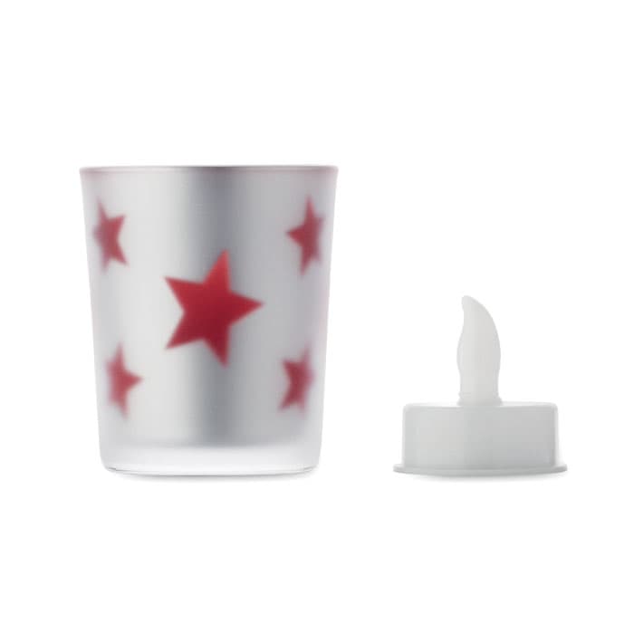 A decorative candle holder with a frosted silver finish and red stars, accompanied by a white candle insert.