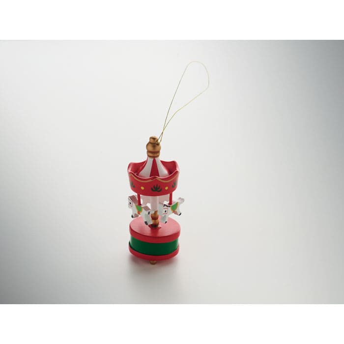 A decorative carousel ornament in red and green, featuring miniature figures and a golden hanging loop.