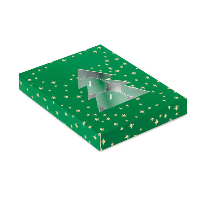 A green gift box with gold stars, featuring a cut-out in the shape of a Christmas tree. The box contains two candles.