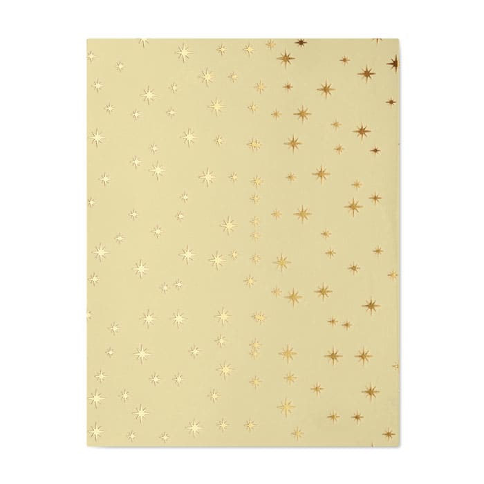 A decorative gold foiled card with a star pattern on a cream background. It features varying sizes of stars.