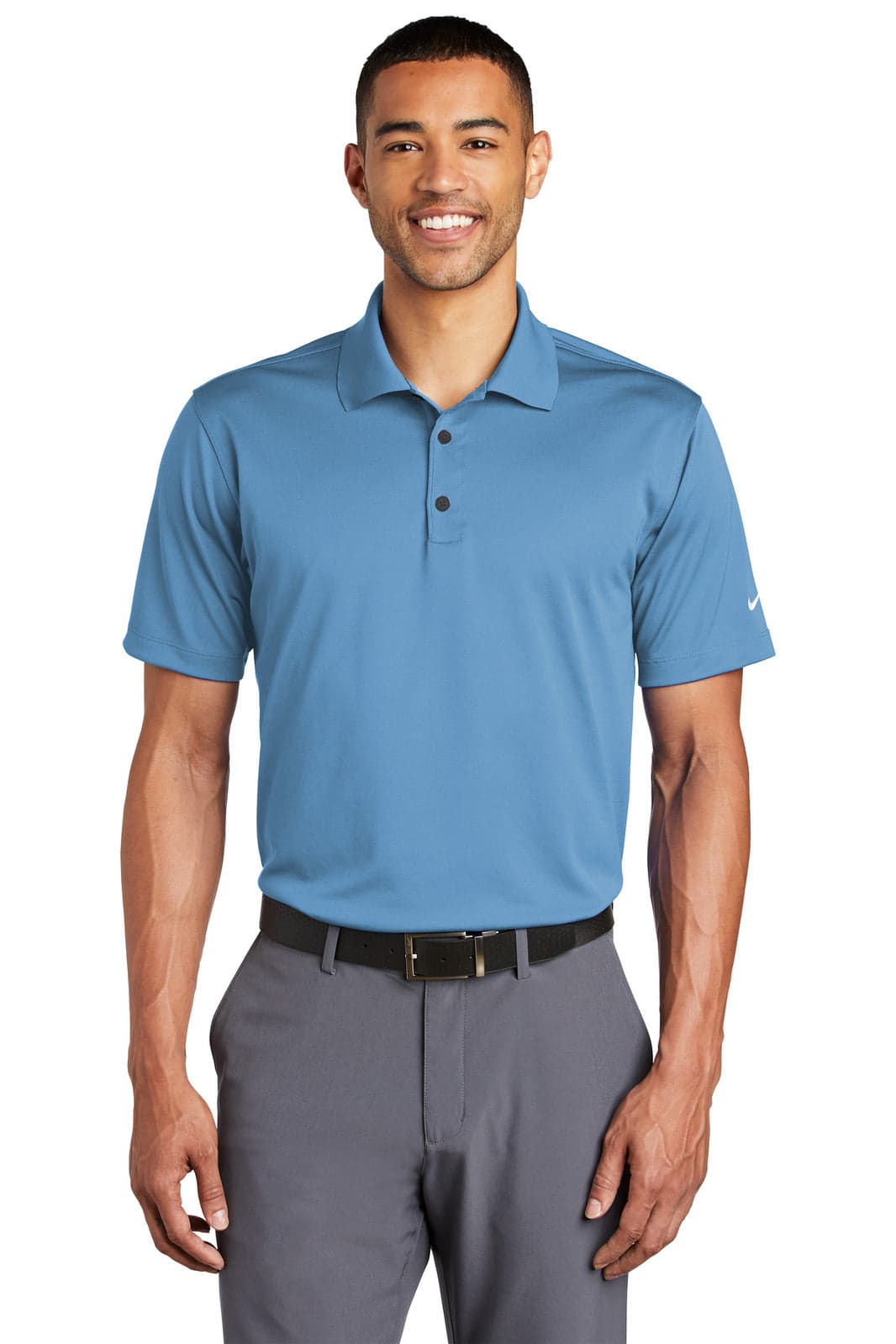 A man wearing a short-sleeve blue polo shirt, paired with grey trousers, featuring a logo on the sleeve.