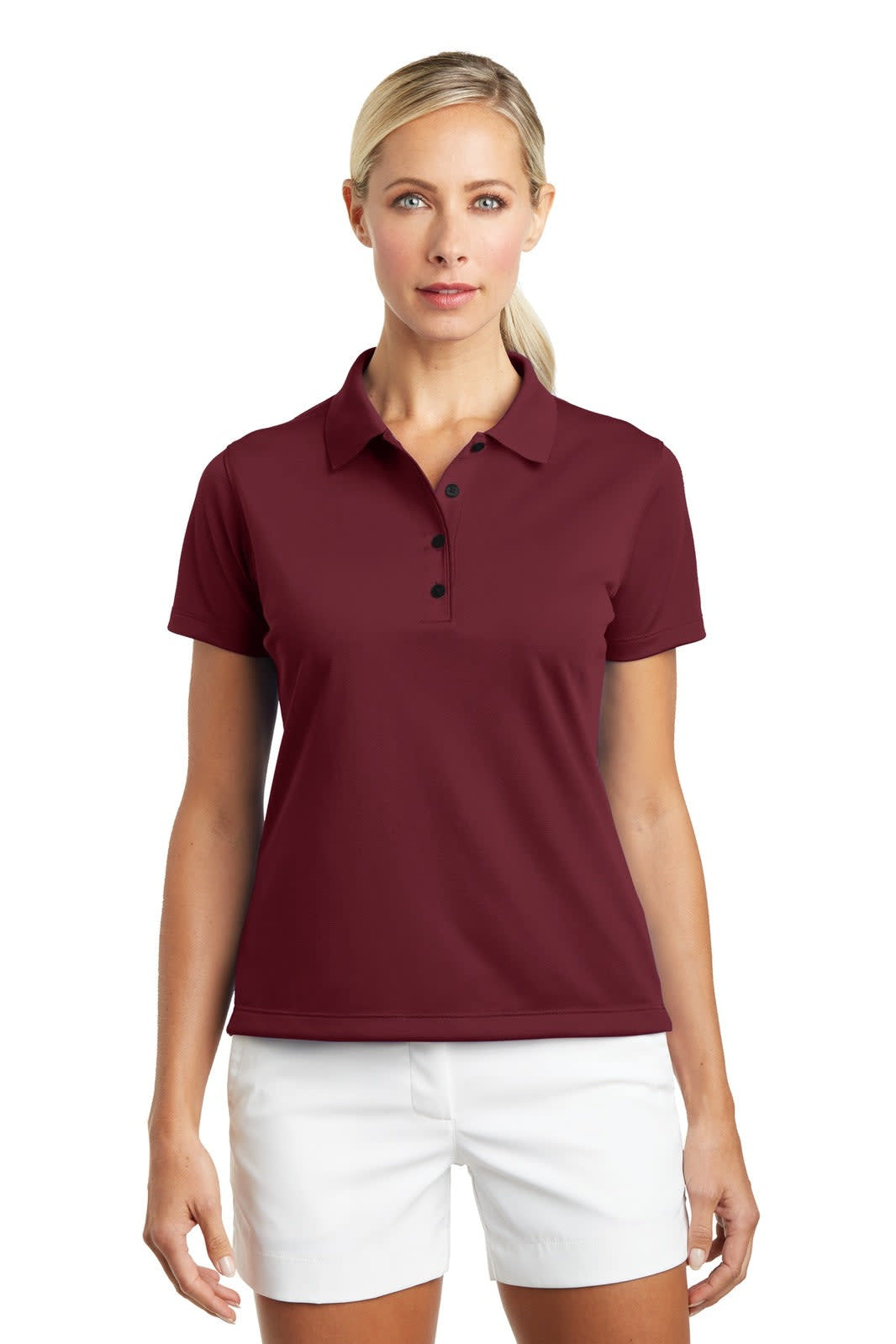 A maroon ladies polo shirt with a collar and buttons, paired with white shorts, featuring a logo.