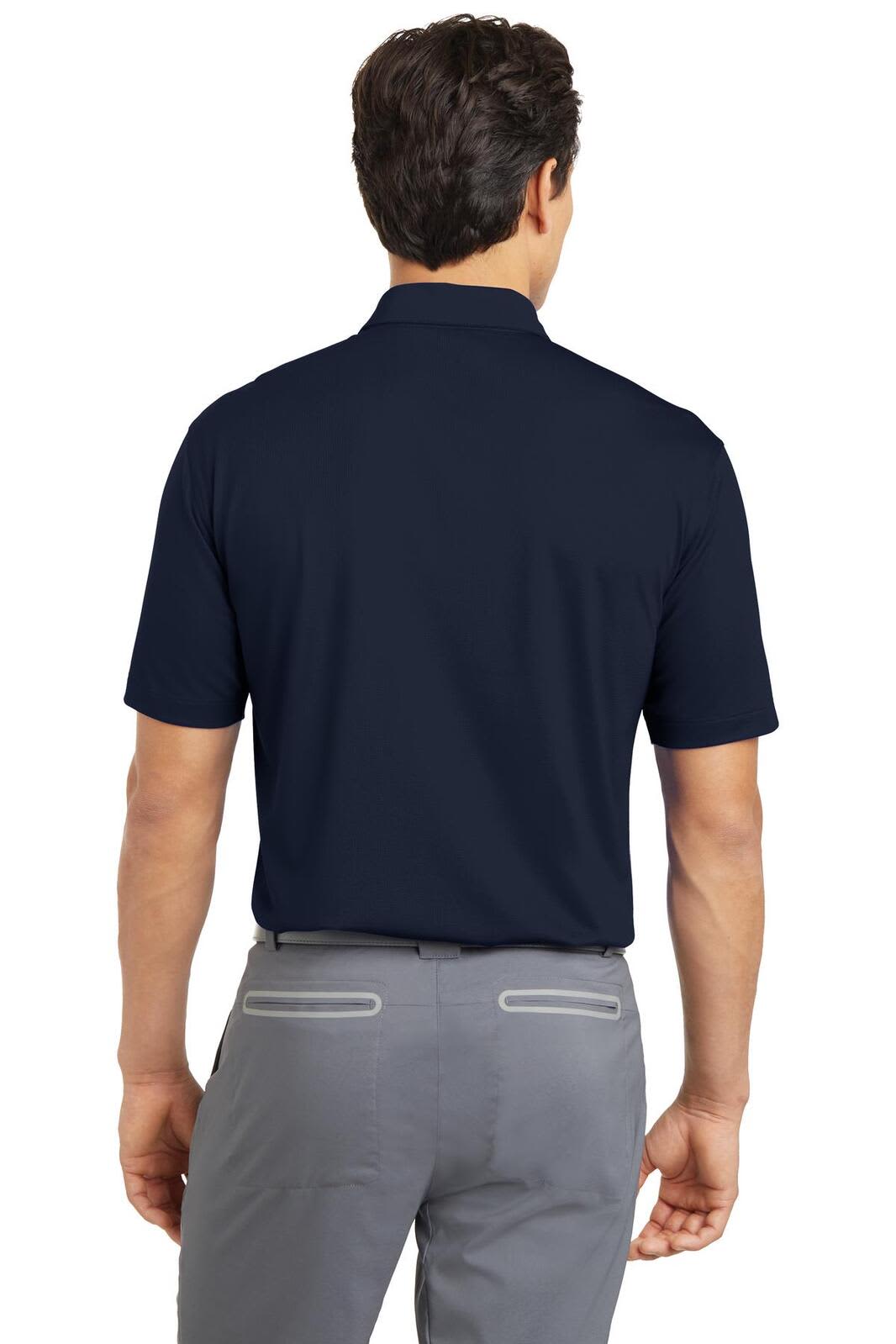 A navy Nike Dri-FIT Vertical Mesh Polo shirt featured on a model from the back, paired with grey trousers.