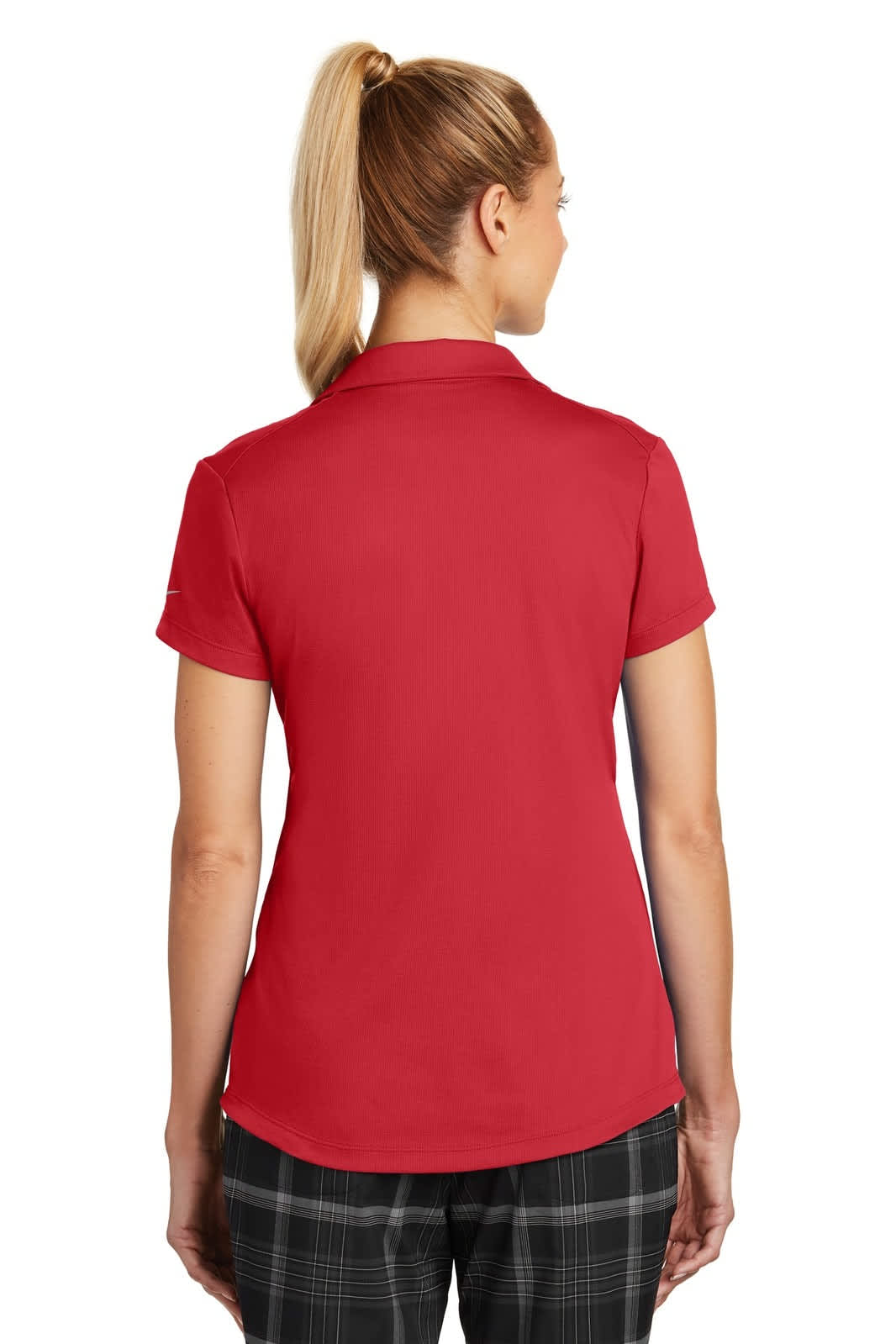 A red Nike ladies' Dri-FIT Legacy polo shirt displayed from the back, featuring a logo. Styled with checked trousers.