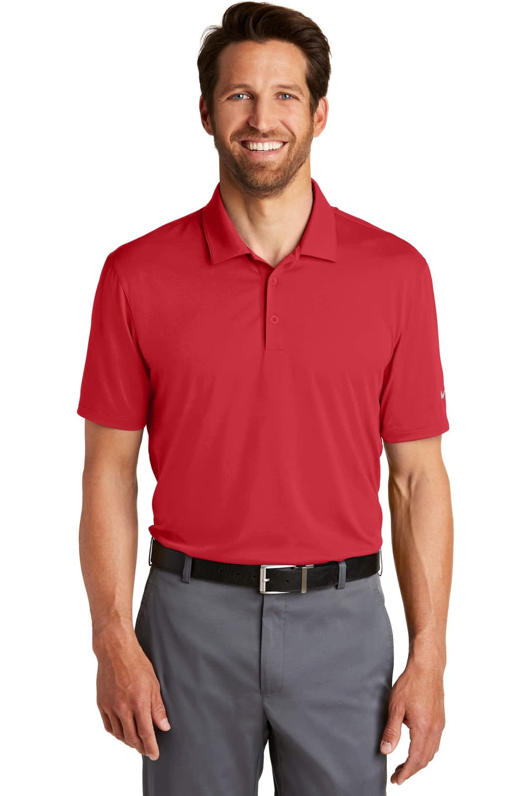 A red Nike Dri-FIT Legacy Polo shirt displayed on a male model, featuring a logo. Styled with grey trousers.