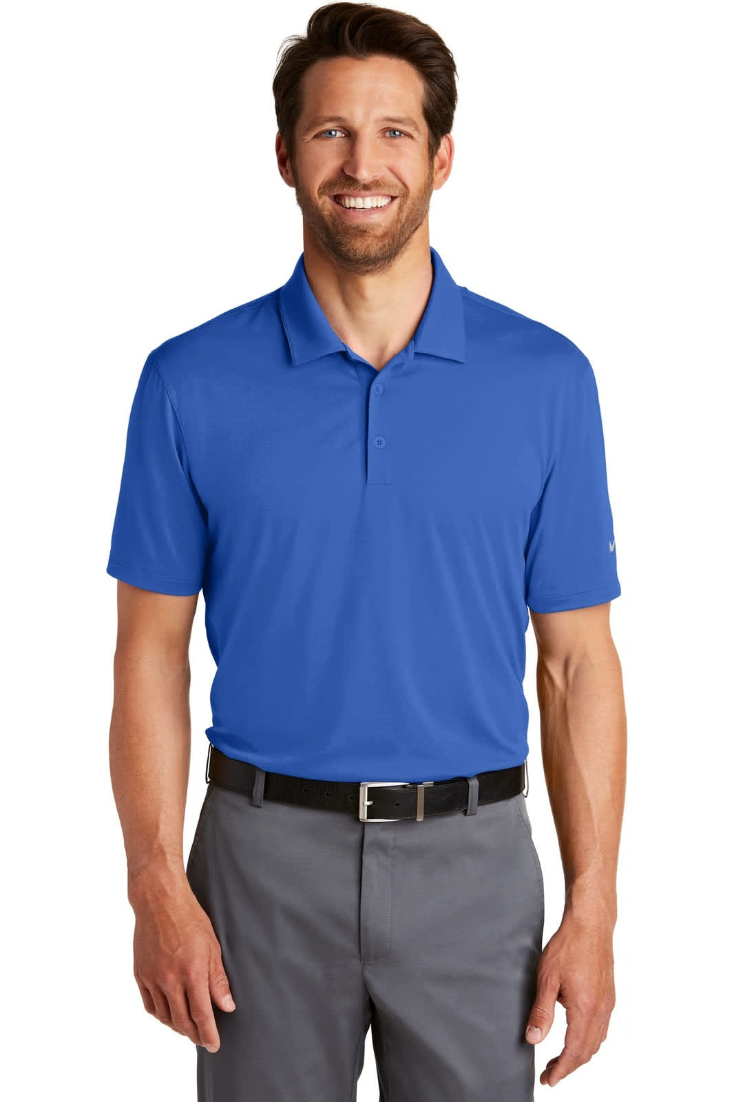 A blue Nike Dri-FIT Legacy Polo shirt worn by a smiling man, paired with grey trousers. The shirt features a logo.