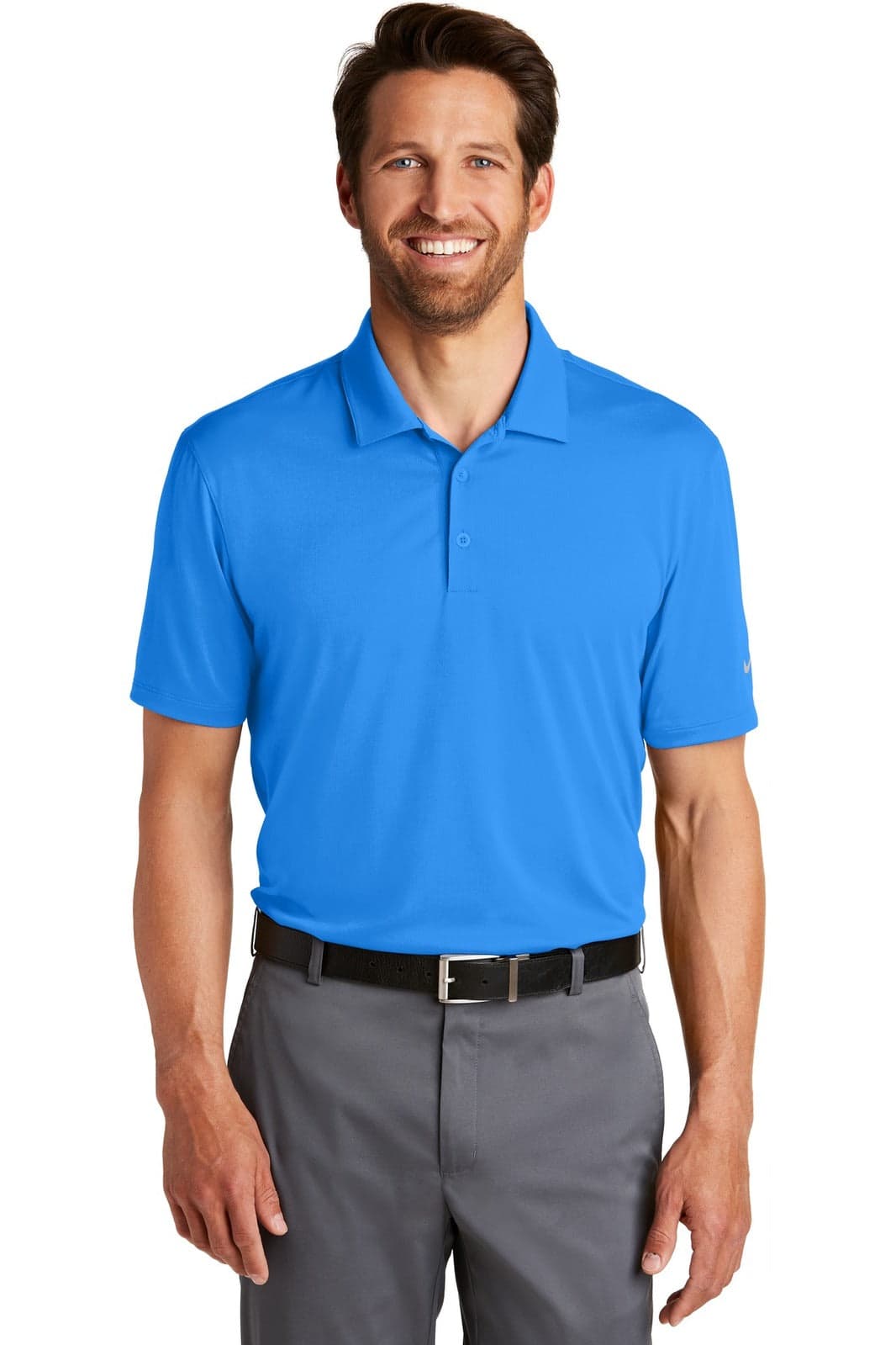 A blue polo shirt with a collar, featuring a logo, worn by a smiling man with dark hair and grey pants.