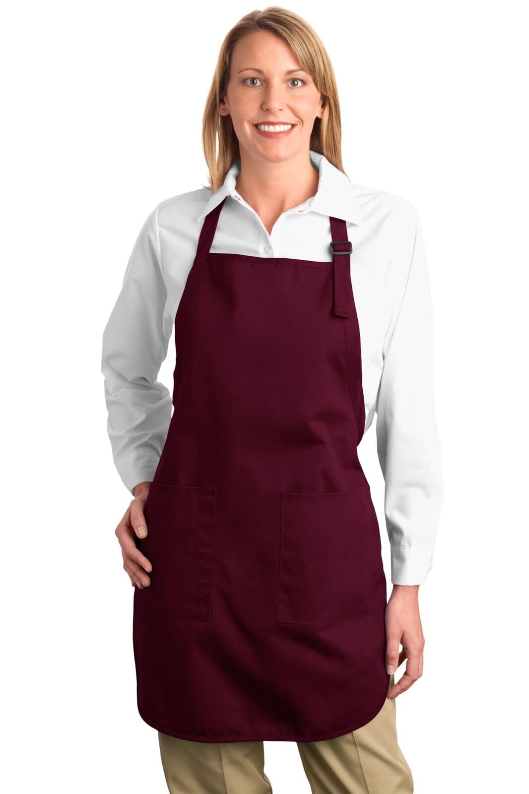 A woman wearing a burgundy full-length apron with pockets over a white shirt and beige pants. The apron has a logo.