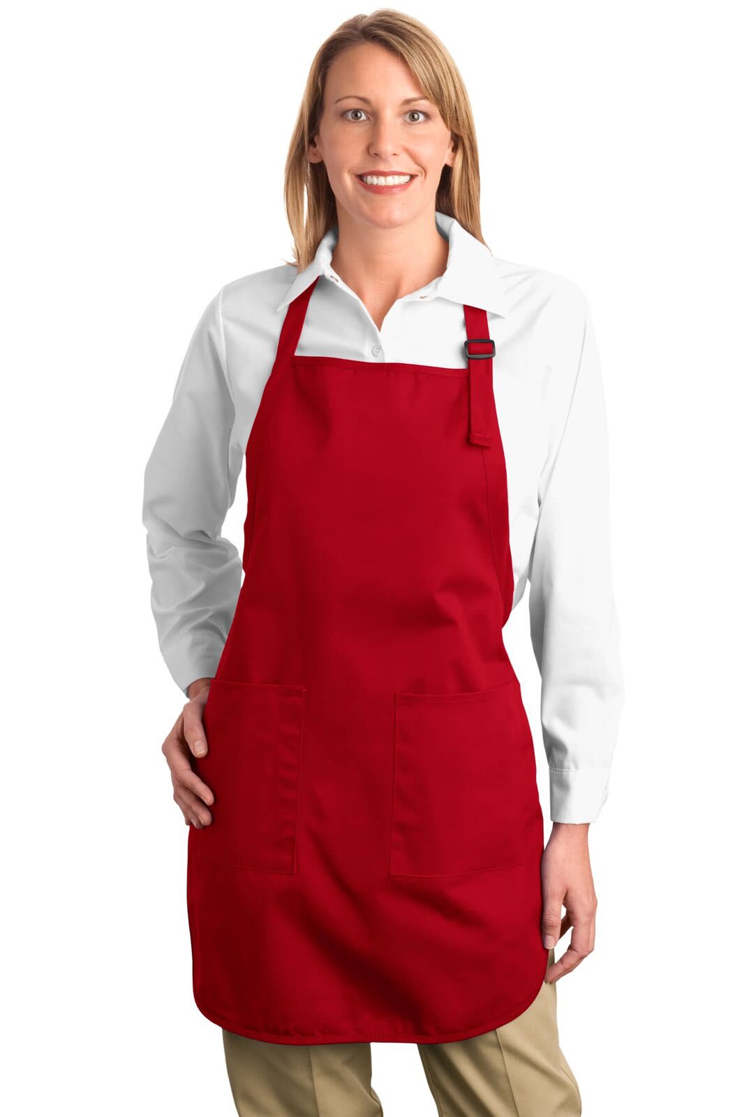 A woman wearing a red full-length apron with pockets over a white shirt, standing and smiling. The apron features a logo.