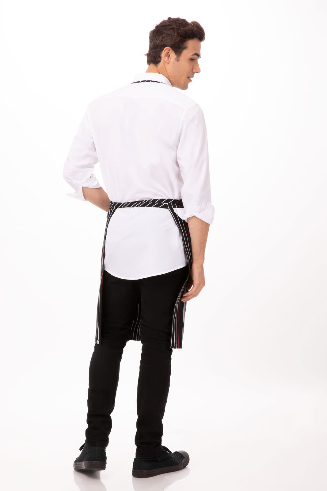 A striped bib apron in black and white worn by a model with a white shirt, viewed from the back.