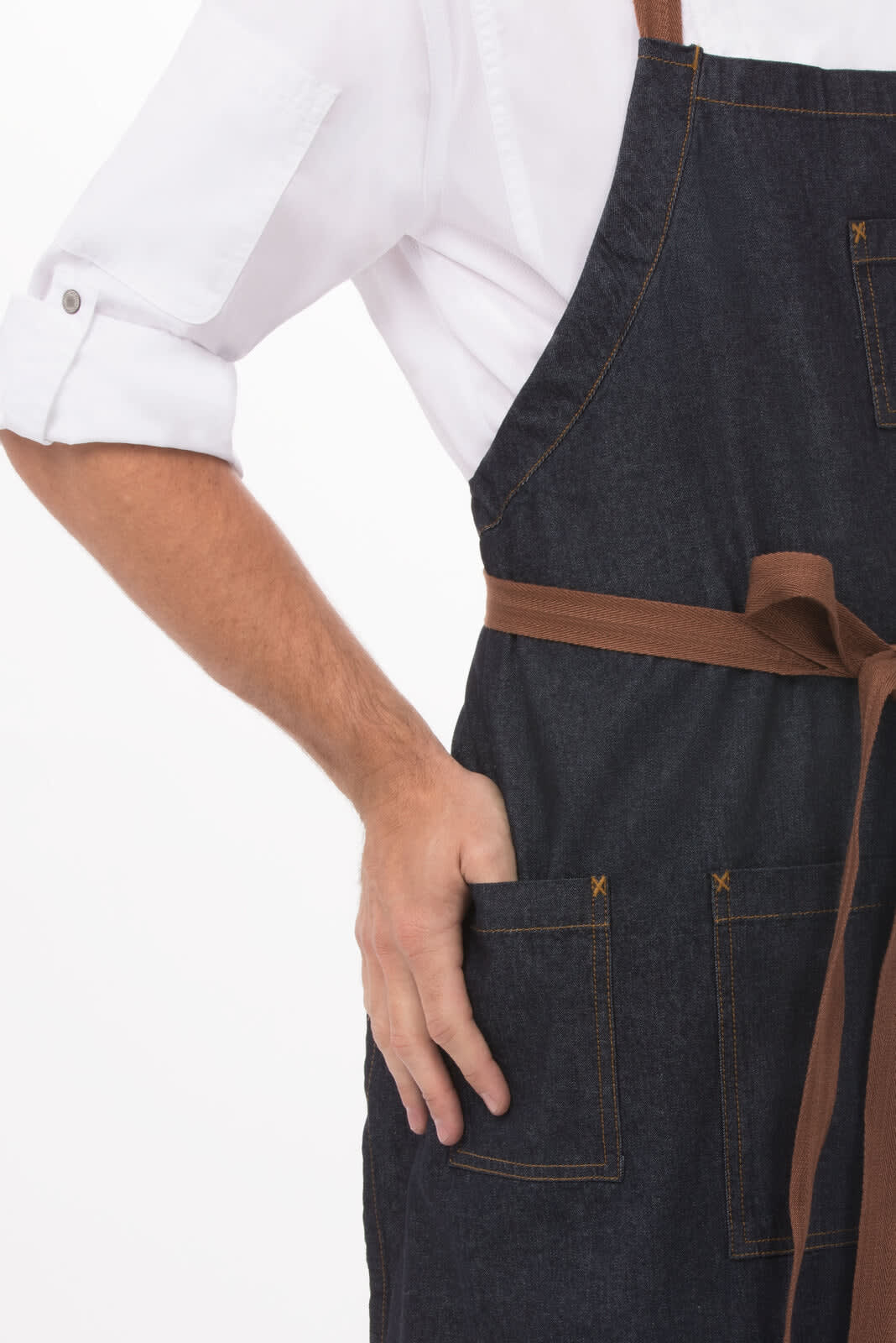 A denim bib apron in dark blue with a brown tie and pockets, featuring a hand resting on one of the pockets.