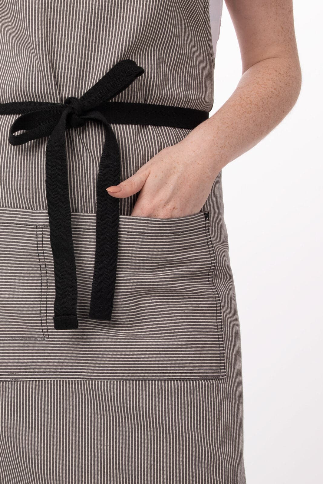 A striped black and white bib apron featuring a front pocket and a tied waistband.