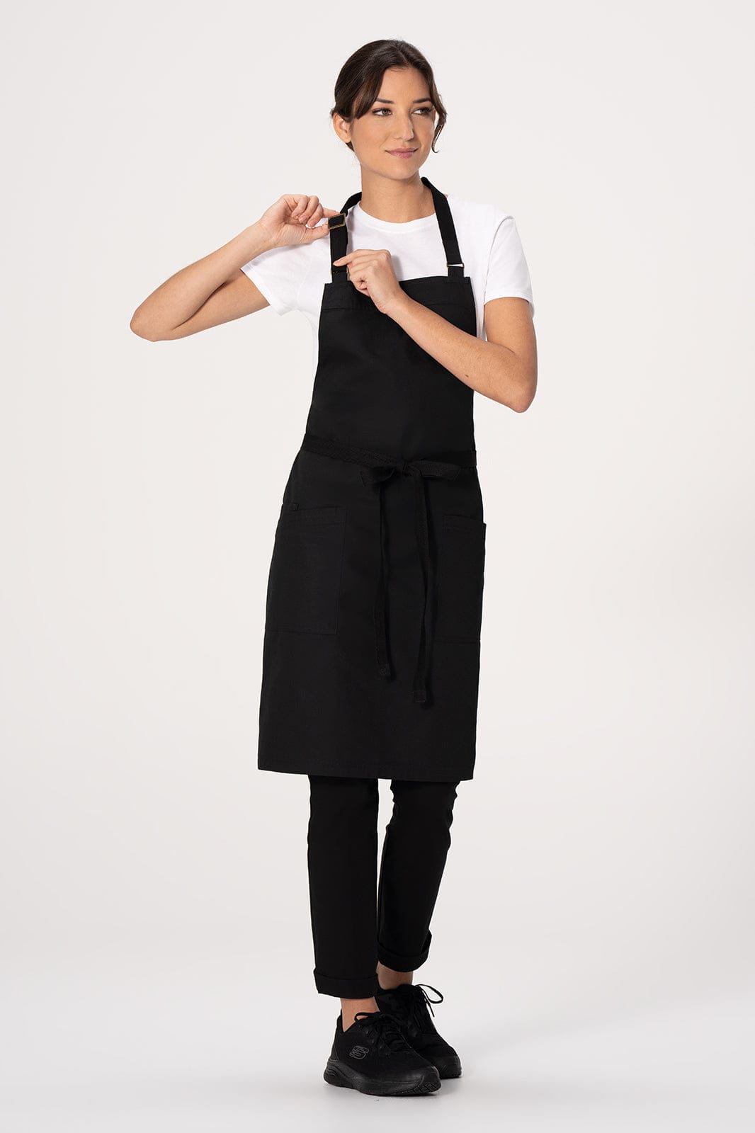 A black Lockharte bib apron worn by a model, featuring adjustable straps and a sleek design.