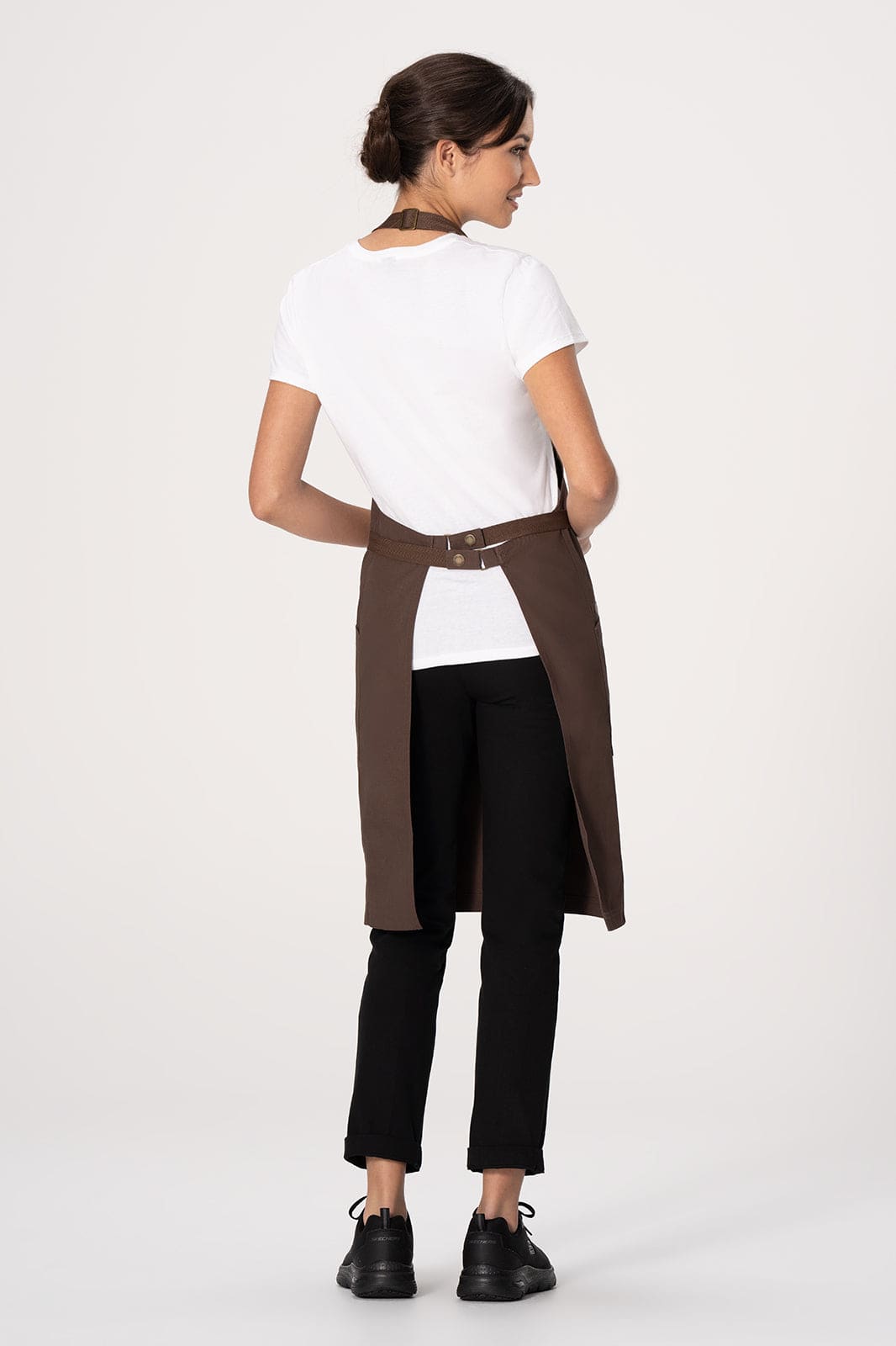 A brown Lockharte Bib Apron worn by a model, featuring a simple design and a logo on the back.