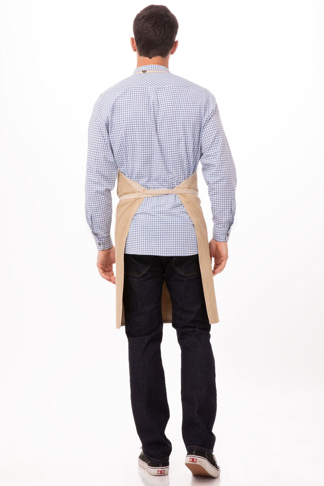 A man is wearing a beige Austin Bib Apron over a checked blue shirt, viewed from the back.