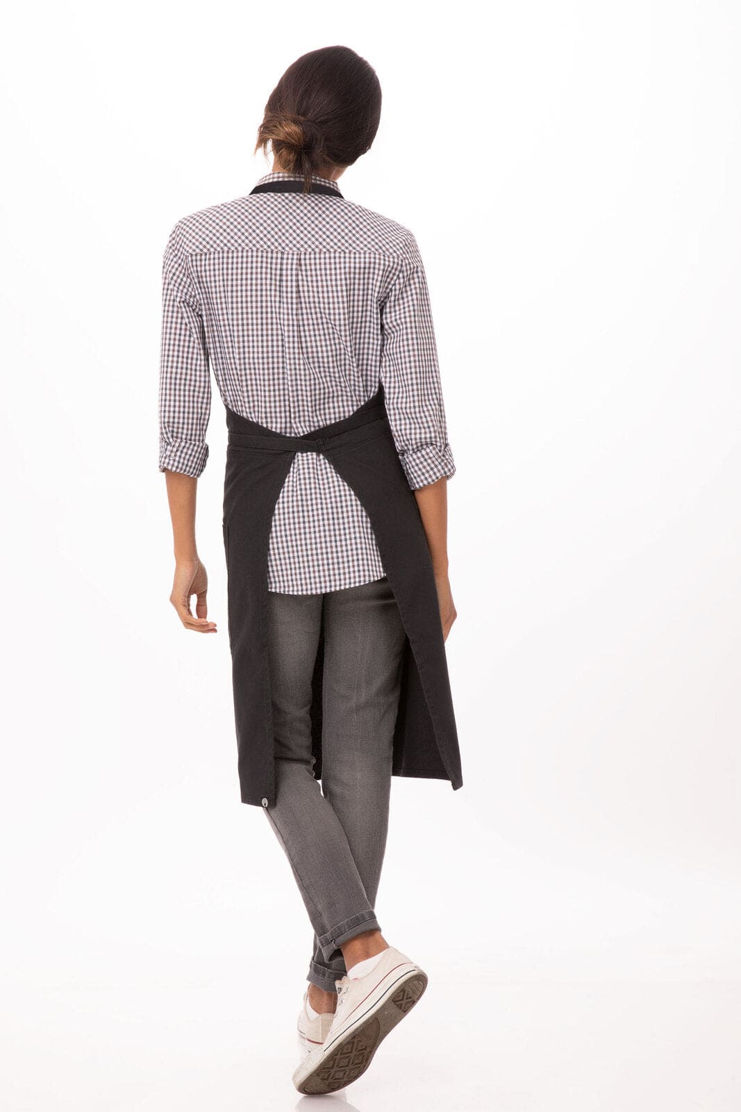 A black Rockford bib apron is worn over a checked shirt and grey jeans, featuring a logo on the back.